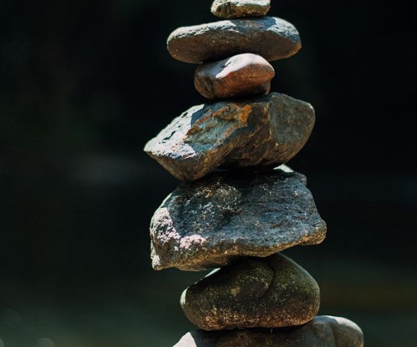 Stack of smooth stones balanced, symbolizing stability and questions.